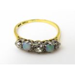 An 18ct ring set with two opals and three diamonds. Ring size approx. O 1/2 Please Note - we do