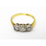 An 18ct gold ring with a platinum set trio of diamonds. Ring size approx. N Please Note - we do