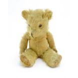 Toy: A 20thC straw filled mohair teddy bear with stitched nose and mouth, pad paws and articulated