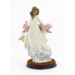 A Lladro figure titled Spring Splendor, model no. 2325. With box and circular wooden stand.
