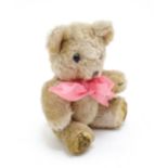 Toy: A small 20thC teddy bear with stitched nose, mouth and claws, pad paws, articulated limbs and a