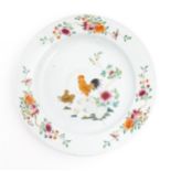 A Chinese famille rose plate decorated with cockerel / rooster, hen and chicks, with peony flowers
