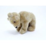 Toys: A 20thC straw filled mohair teddy bear on all four legs with a stitched nose, mouth and claws,