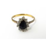 A 9ct gold ring set with central blue stone bordered by white stones. Ring size approx. L 1/2 Please