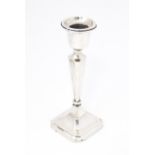 A silver candlestick hallmarked Birmingham 1915 maker Henry Williamson Ltd Approx. 6" high Please