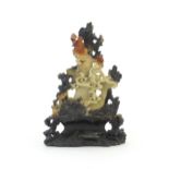 An Oriental soapstone carving depicting a rocky outcrop with immortal figures amongst clouds.