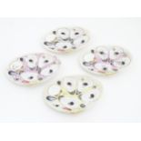 Four Union Porcelain Works oyster plates of shell form with relief seaweed and shell detail.