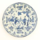 A Chinese blue and white plate / dish decorated with two ladies in a garden landscape with a