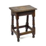 An early 18thC oak joint stool with a moulded rectangular top above a peg jointed base, carved