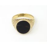 A 9ct gold signet ring set with onyx. Ring size approx. M 1/2 Please Note - we do not make reference