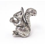 A miniature silver model of a seated squirrel with a nut, hallmarked London 1976. Approx. 1" high
