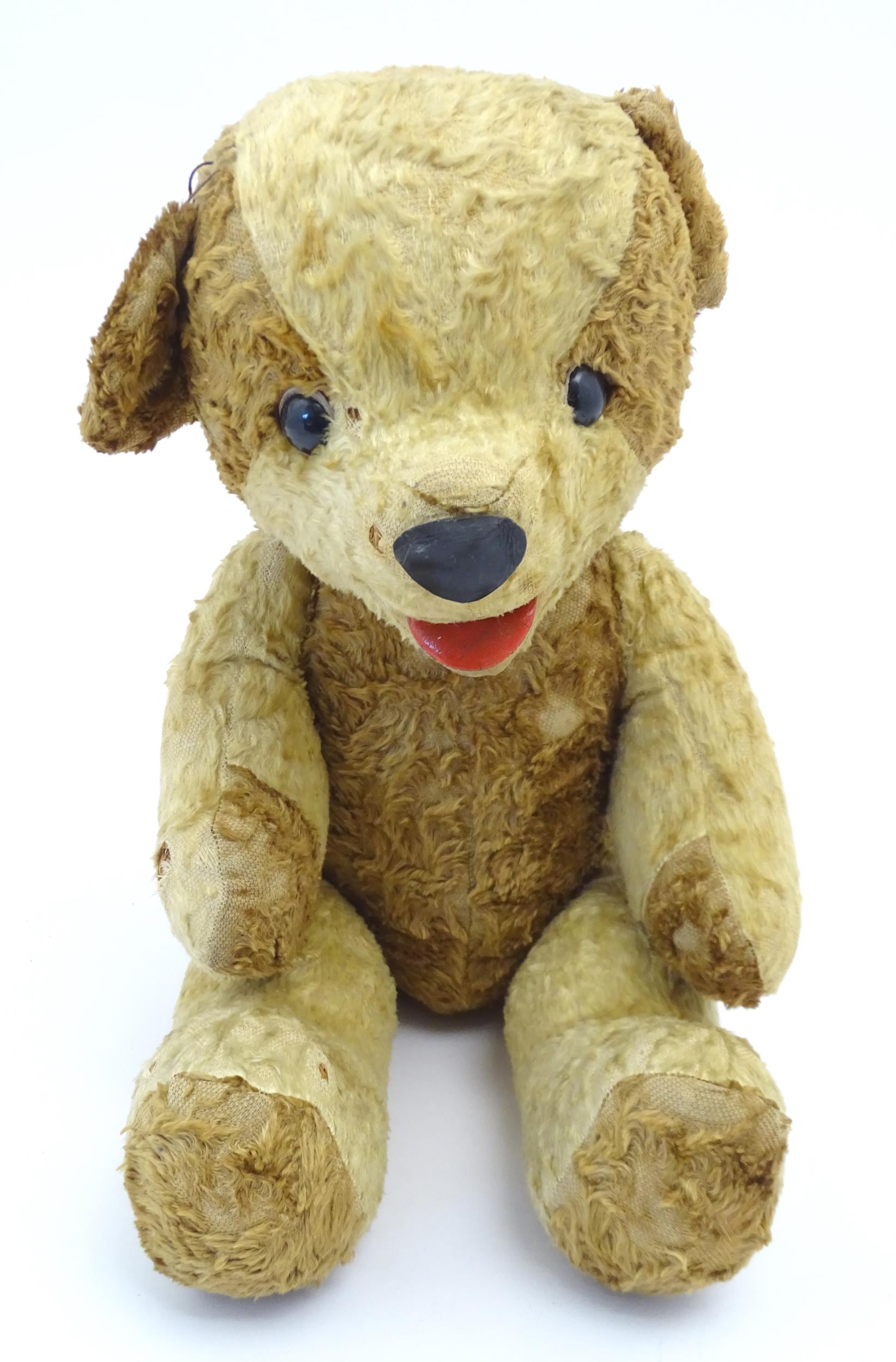 Toy: A 20thC straw filled teddy bear with leather tongue and articulated limbs. Approx. 22 1/2"