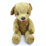 Toy: A 20thC straw filled teddy bear with leather tongue and articulated limbs. Approx. 22 1/2"