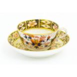 A Derby porcelain tea cup and saucer decorated in the Imari pattern. Marked under. Saucer approx.