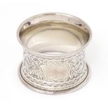 A silver napkin ring with engraved acanthus scroll decoration, hallmarked Birmingham 1906 Please