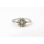 A platinum ring set with six diamonds in a daisy setting. Setting approx. 1/4" diameter. Ring size