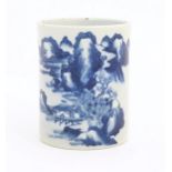 A Chinese blue and white brush pot of cylindrical form decorated with a mountain landscape.