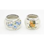 Two ceramic salts with silver rims, one with forget me not flower detail, the other with crest for