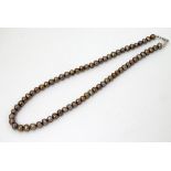 A necklace of brown pearls. approx 15" long Please Note - we do not make reference to the