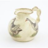 A Yorkshire Moorlands pottery jug with twist handle decorated with geese. Marked under. Approx. 4
