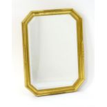 A 21stC mirror with gilt frame of octagonal form with moulded decoration and a bevelled glass to the