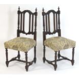 A pair of late 19thC carved oak side chairs surmounted by turned finials and having carved