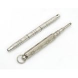 A white metal propelling pencil. Together with a miniature screwdriver tool. Pencil approx. 2 1/2"