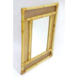 A wall mirror with bamboo and rattan frame, approx 22 1/2" x 28 1/2" Please Note - we do not make