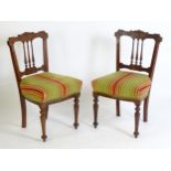 A pair of early 20thC side chairs with carved backrests and turned tapering spindles, above sprung