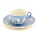 A Wedgwood Jasperware tea cup and saucer decorated with classical figures in relief. Cup approx.