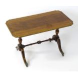 A mid 20thC mahogany coffee table with inlaid brass work decoration and an embossed surround, the