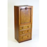 A late 19thC / early 20thC mahogany cabinet with a panelled door above a three short drawers with