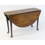 A late Georgian mahogany drop flap table, the table having two demi lune leaves and raised on turned