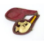 A 19thc ladies' cased smoking pipe, the carved meerschaum bowl with spaniel dog decoration and amber
