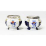 Two porcelain pots / salts with silver rims hallmarked London 1906. Approx 2 1/4" in diameter, 1 3/