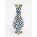 An Iznik style vase with banded blue, white and red floral and foliate detail. Approx. 11 1/2"