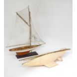 A mid 20thC wooden pond yacht / model boat on stand, with painted finish and cotton sails,