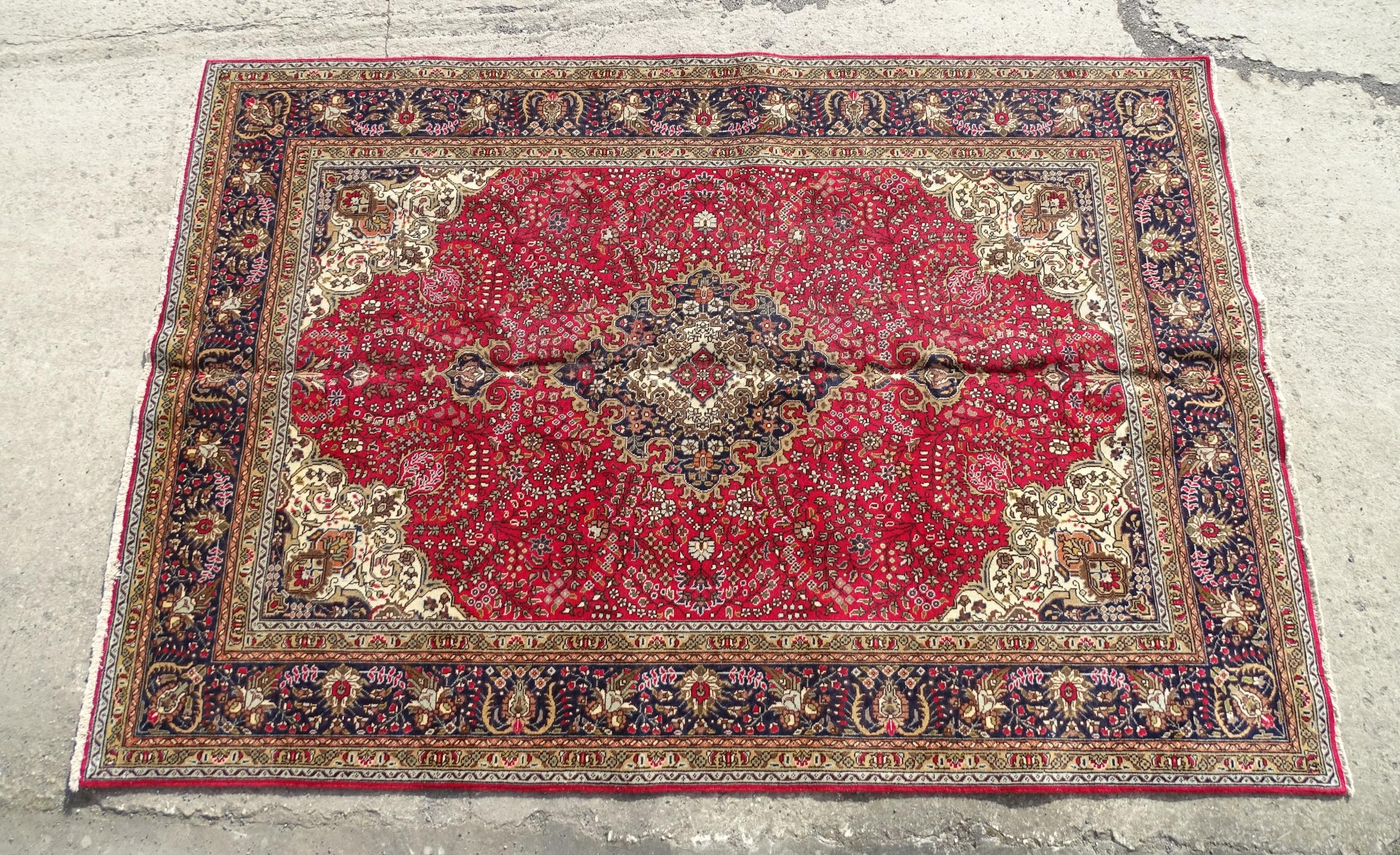 Carpet / Rug : A North West Persian Tabriz carpet, the red ground with central medallion of floral