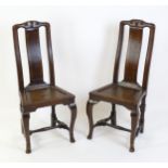 A pair of early 18thC oak side chairs, with carved top rails decorated with scrolls and floral