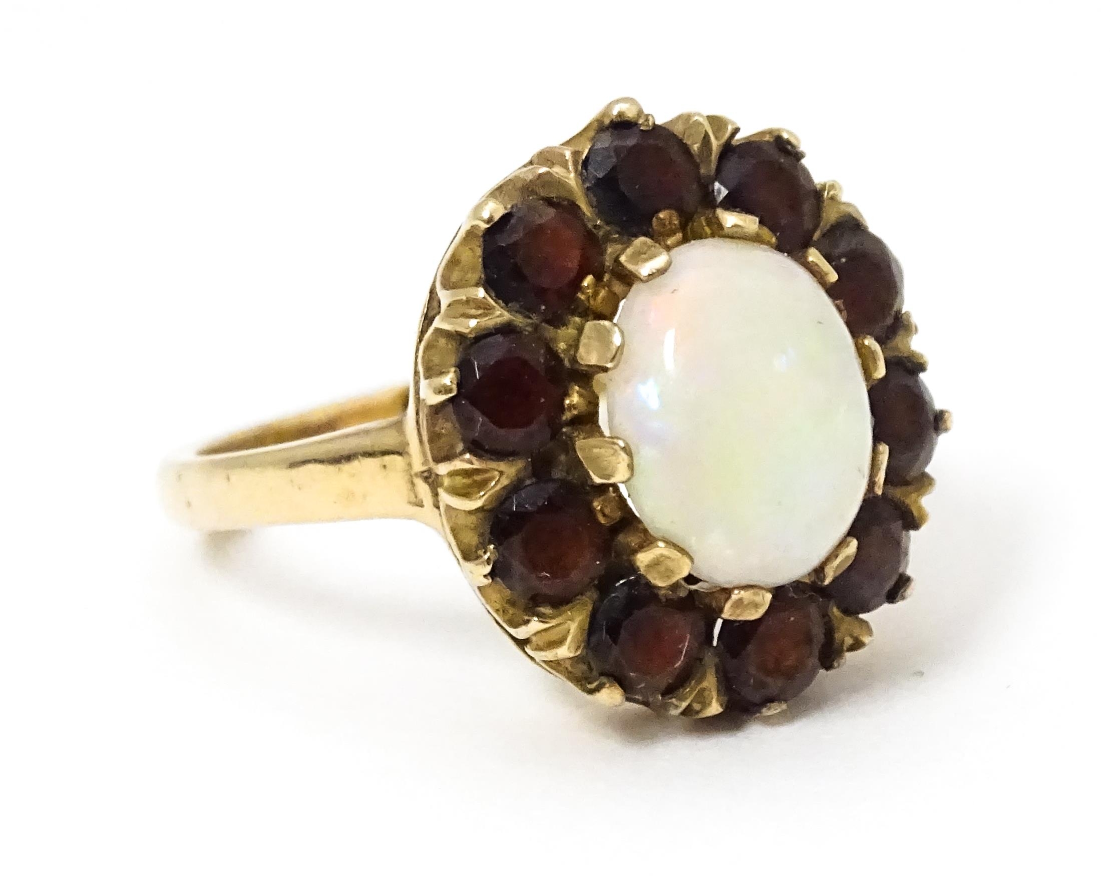 A 9ct gold ring set with central opal bordered by garnets. Ring size approx. L Please Note - we do - Image 3 of 7