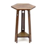 An Arts & Crafts oak occasional table with a hexagonal top above three tapering legs with floral