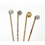 Four assorted gold and yellow metal stick pins set with diamonds. Largest approx. 2 1/2" long (4)