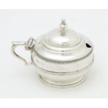 A silver mustard pot with blue glass liner hallmarked Birmingham 1919 maker Collingwood & Sons