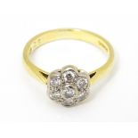 An 18ct gold ring set with 7 diamonds in a daisy setting. Ring size approx. H Please Note - we do
