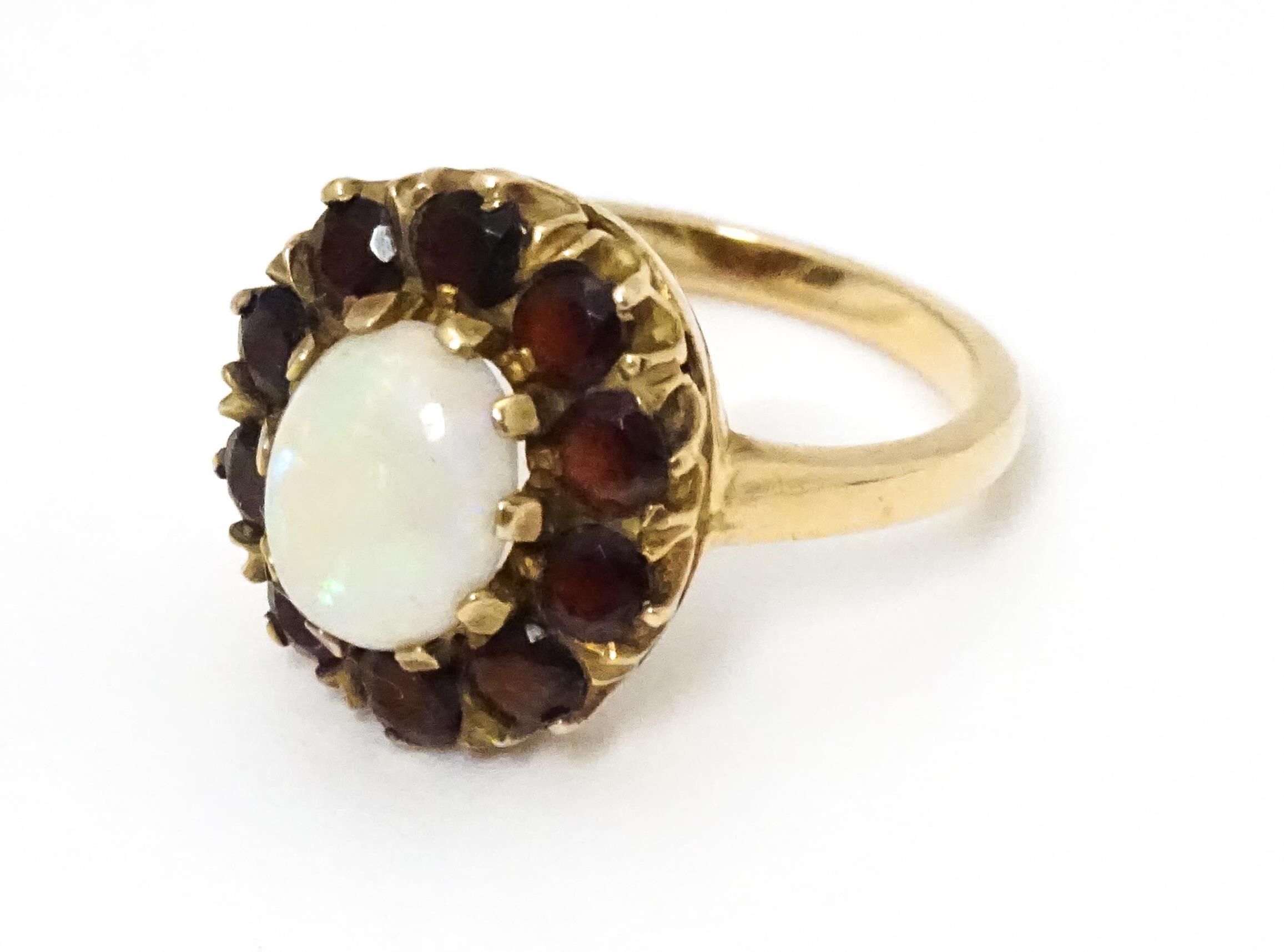 A 9ct gold ring set with central opal bordered by garnets. Ring size approx. L Please Note - we do - Image 2 of 7