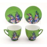 Two Art Deco cups and saucers with a green ground and hollyhock flower decoration. Marked Carlton