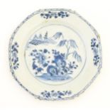 A Chinese blue and white plate of octagonal form decorated with a landscape with flowers, trees