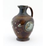 A Doulton Lambeth jug with relief blossom detail. Marked under, with maker's mark for Kate