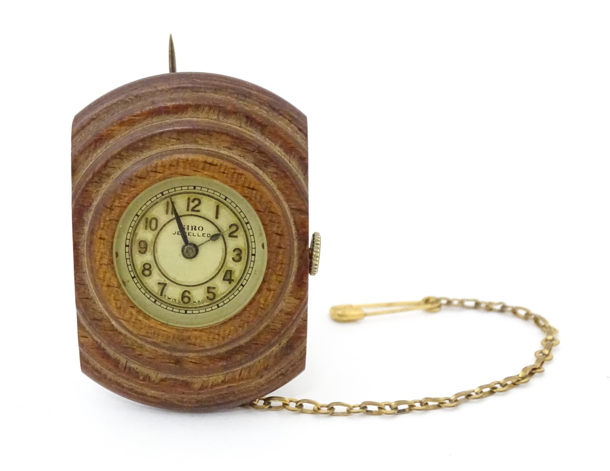 An unusual watch formed as a brooch, the Siro watch with 15 jewel movement mounted within a carved