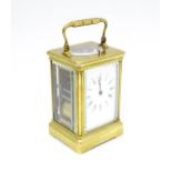 A brass repeater carriage clock with white enamel dial and movement striking on a gong. Please